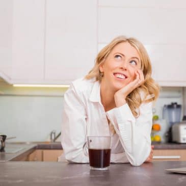 woman in the kitchen with coffee daydreaming