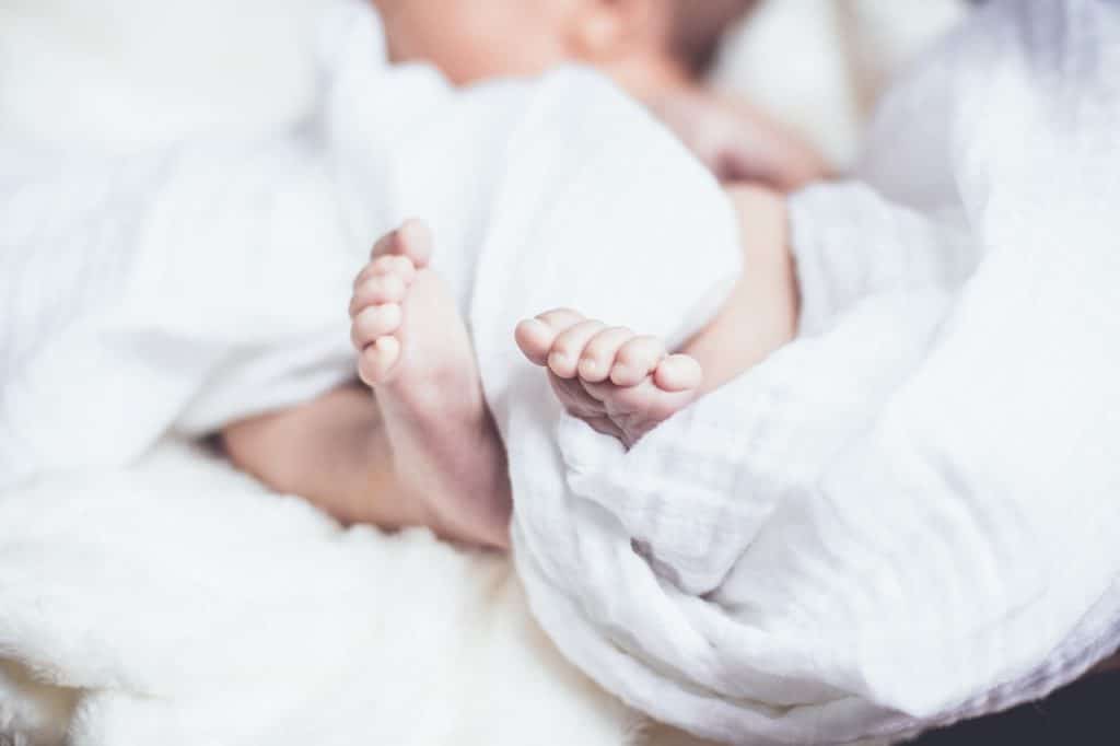 newborn on white sheet