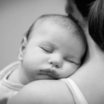 woman with newborn on her shoulder