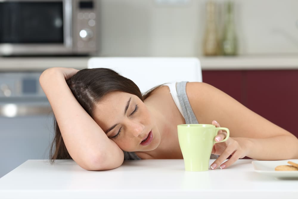 woman tired on table with coffee