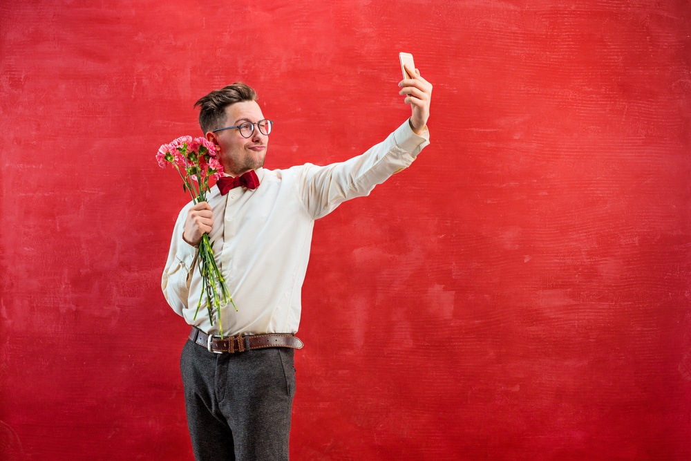 man with flowers and phone