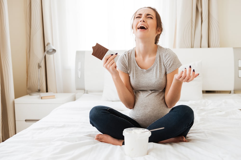 pregnant woman eating chocolate and crying
