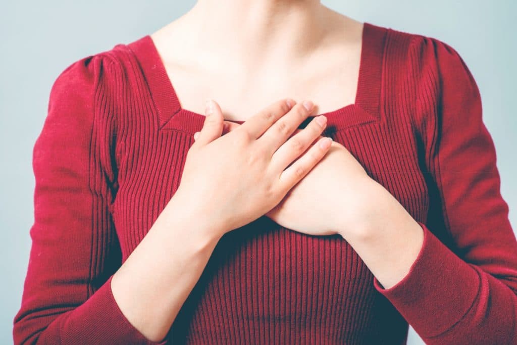 woman with hands on chest