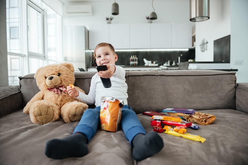 boy watching tv with candies