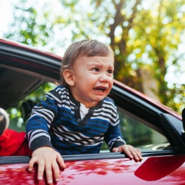 crying baby boy in a car