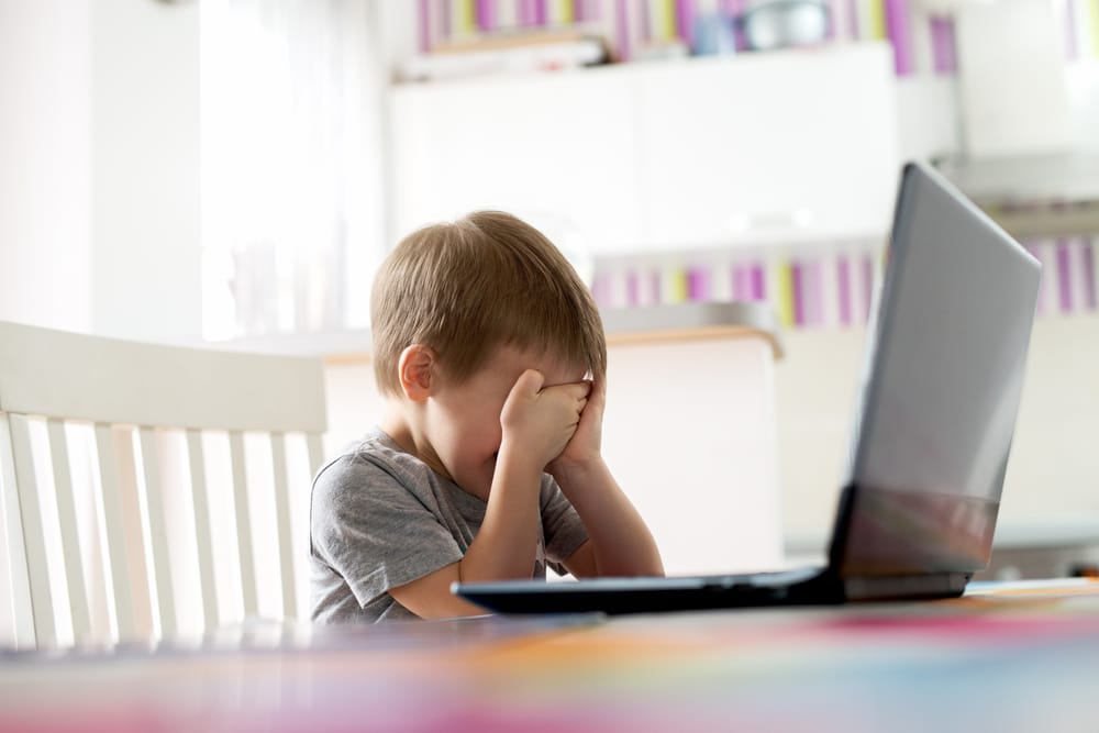 little boy crying in front of a computer
