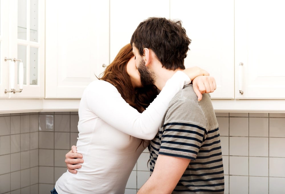 couple kissing in kitche