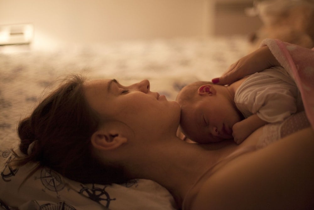 sleepy mother with newborn