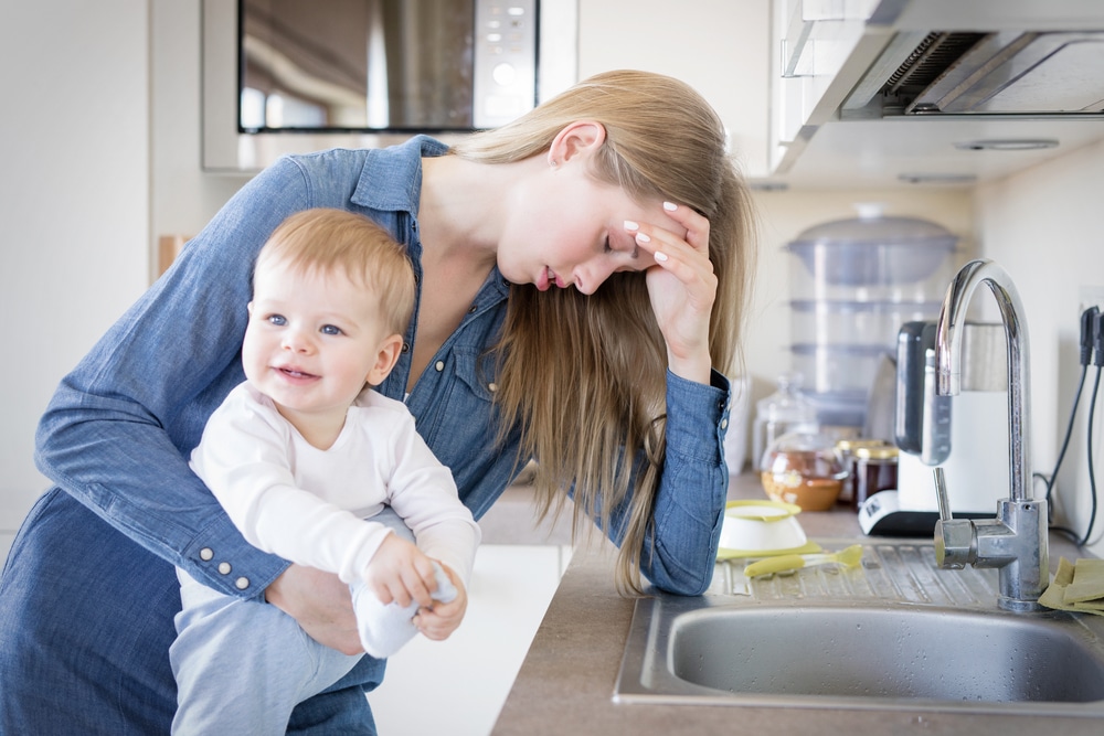 depressed mother in kitchen with babyb