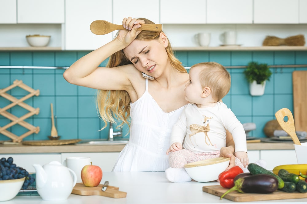 stressed mother in kitchen with baby