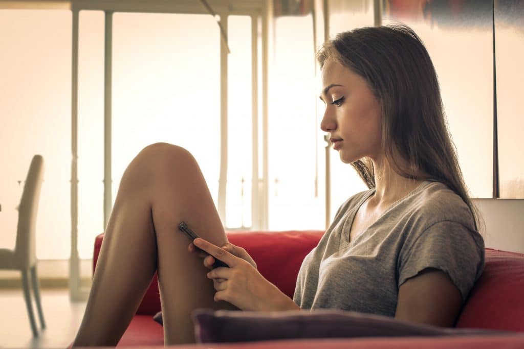 woman waiting on couch with cellphone