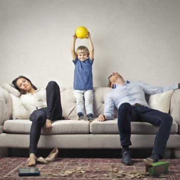 tired parents with kid on couch