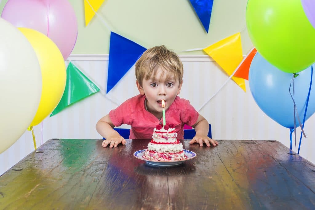 little boy blowing candles on cake