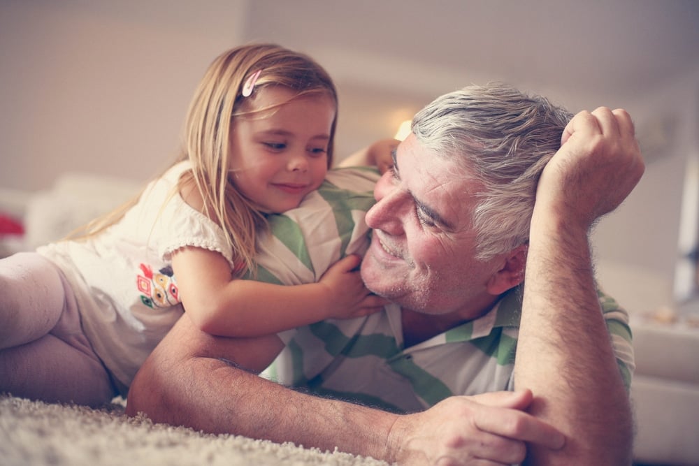 little girl and grandfather on living room