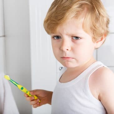 unhappy kid brush his teeth