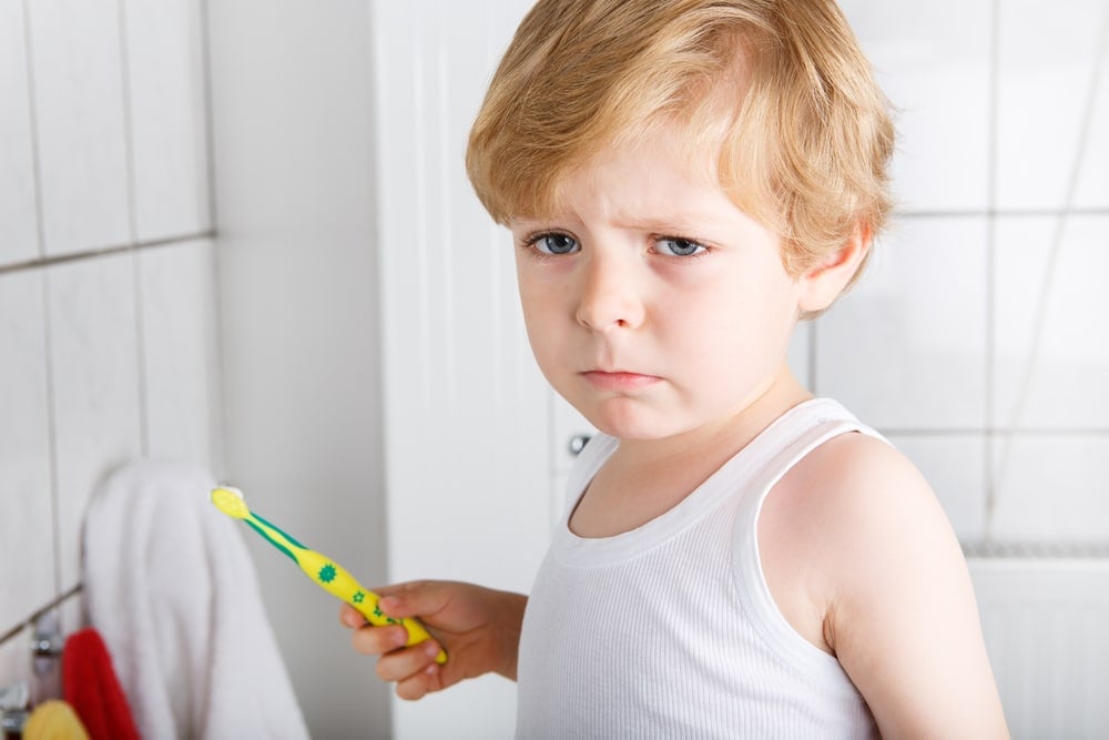 unhappy kid brush his teeth