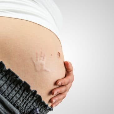 pregnant woman with baby handprint