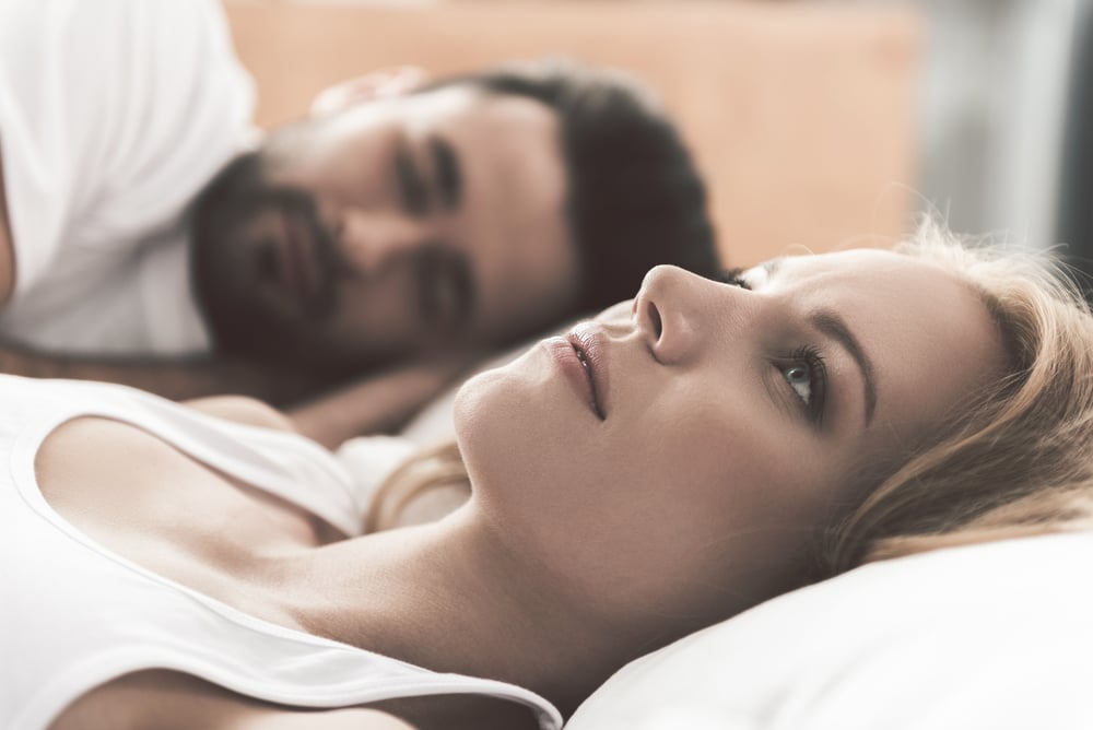 depressed woman with man in bed