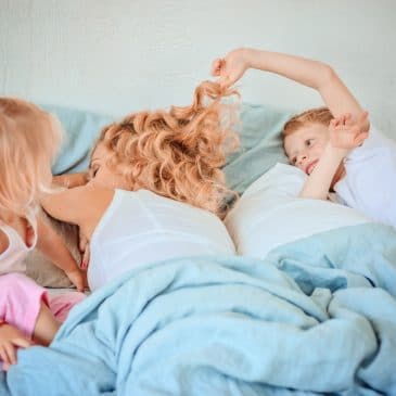 kids pulling air of mother in bed