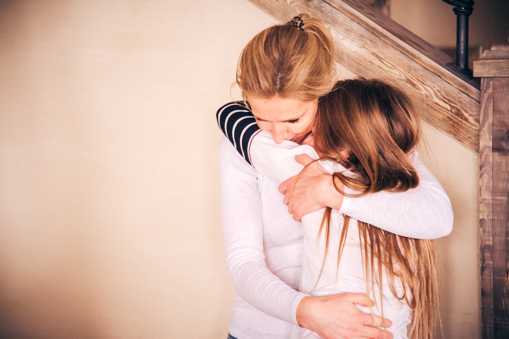 mother embrace crying teenager girl