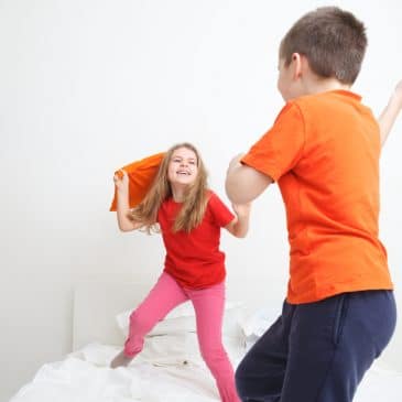 two kids fighting on bed