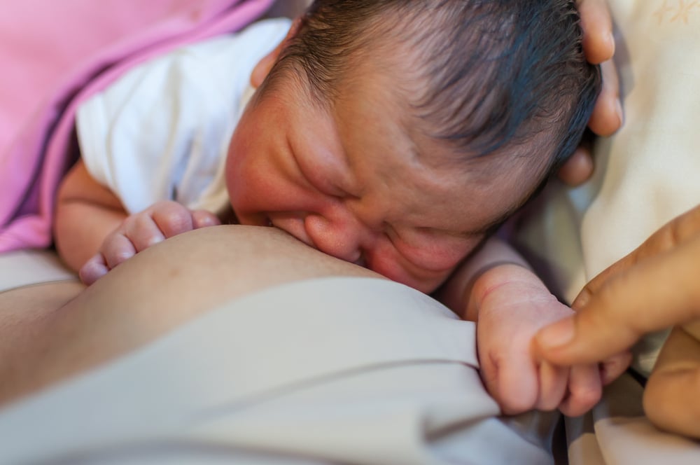 woman breastfeeding crying baby