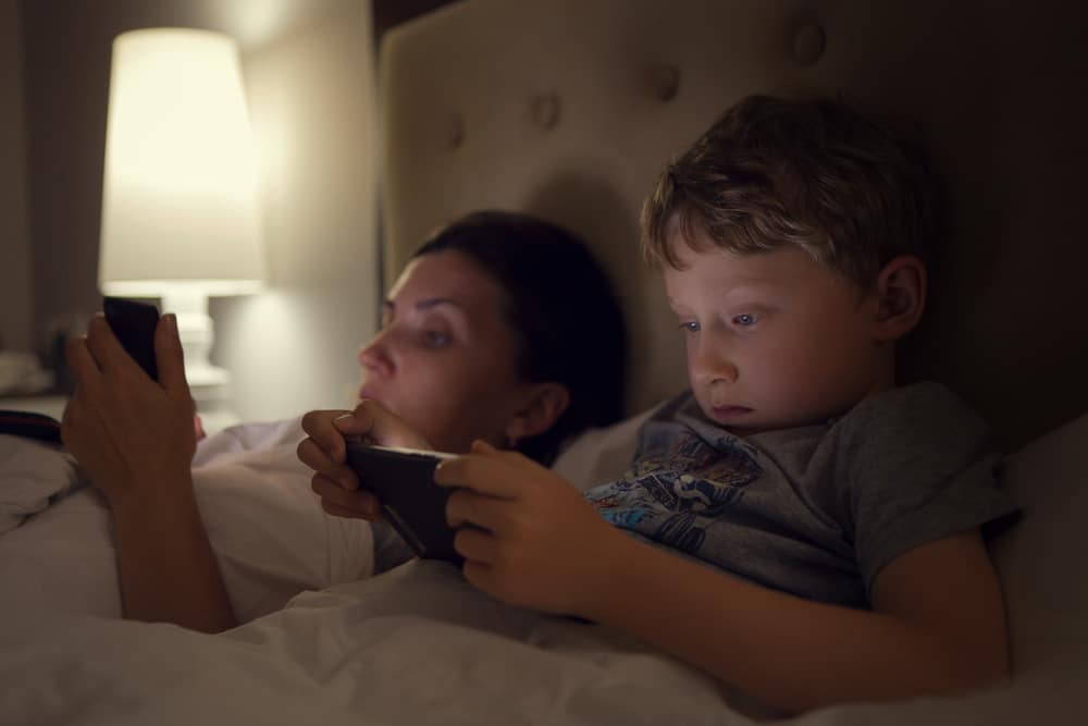 mother and son on bed with cellphone
