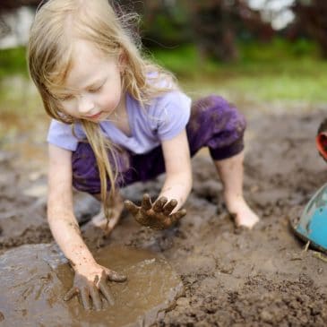 little girl playing in mud
