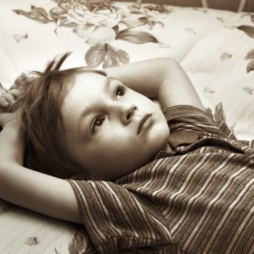 little boy alone on a bed