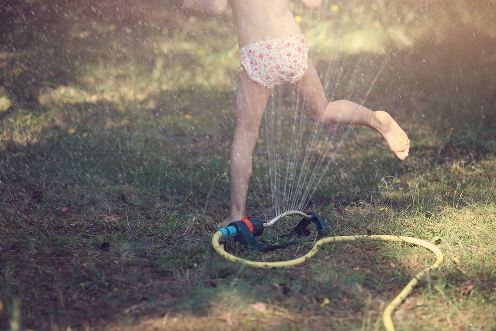 kid play with hose outside