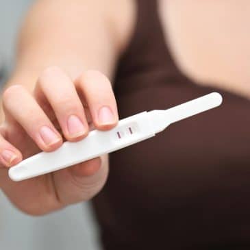 woman show pregnancy test