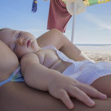 mother and baby sleep at the beach