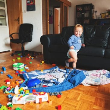 little kid in messy living room