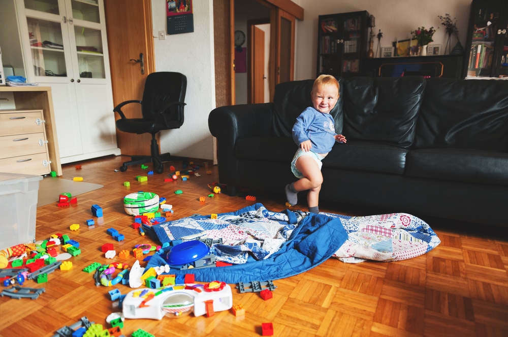 little kid in messy living room