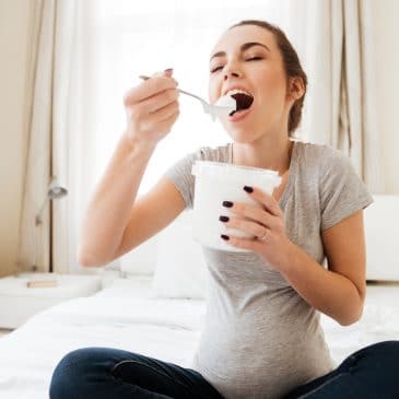 happy pregnant woman eating icecream