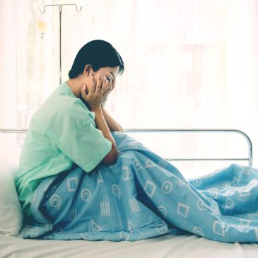woman crying in hospital bed