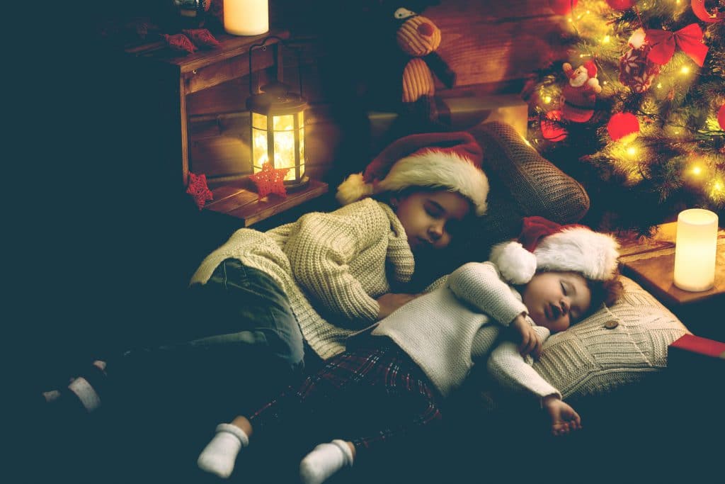two little girls sleeping xmas tree