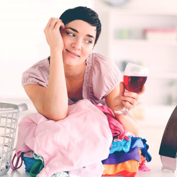 woman drinking wine with laundry