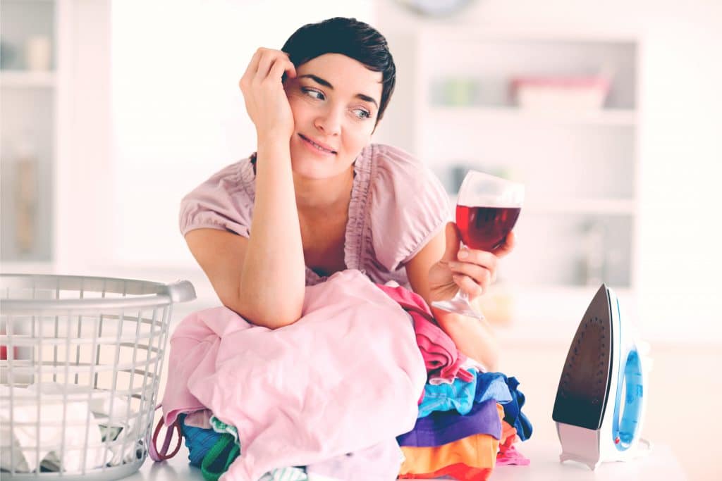 woman drinking wine with laundry