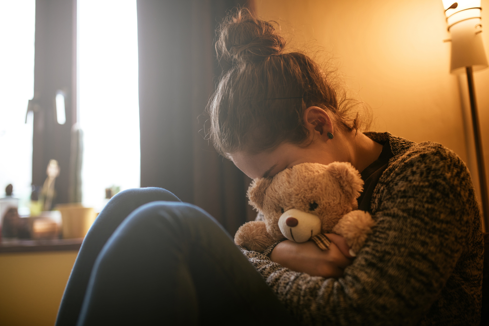 sad woman with teddy bear