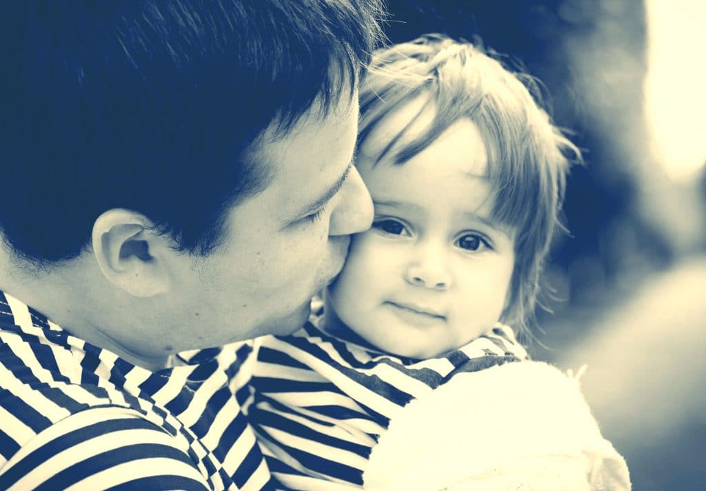 father kiss little girl
