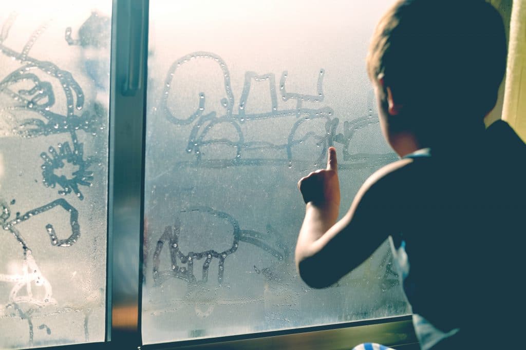 little boy in front of window