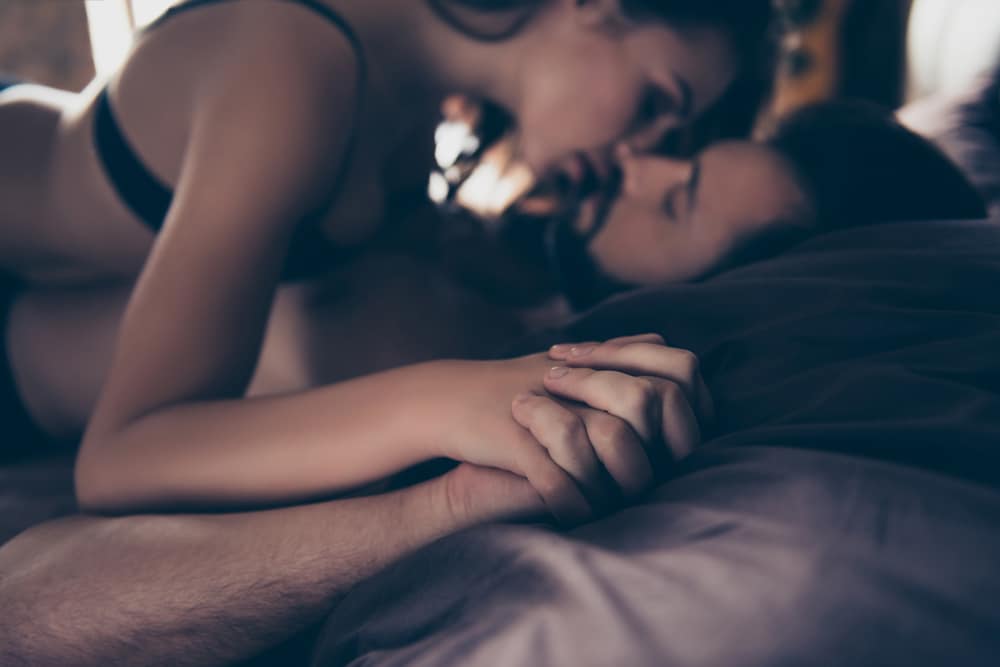 woman man kiss bed