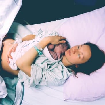 mother with newborn in hospital bed