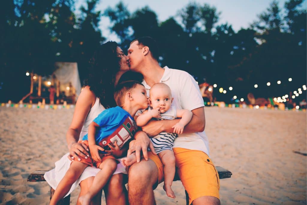 family kiss on beach
