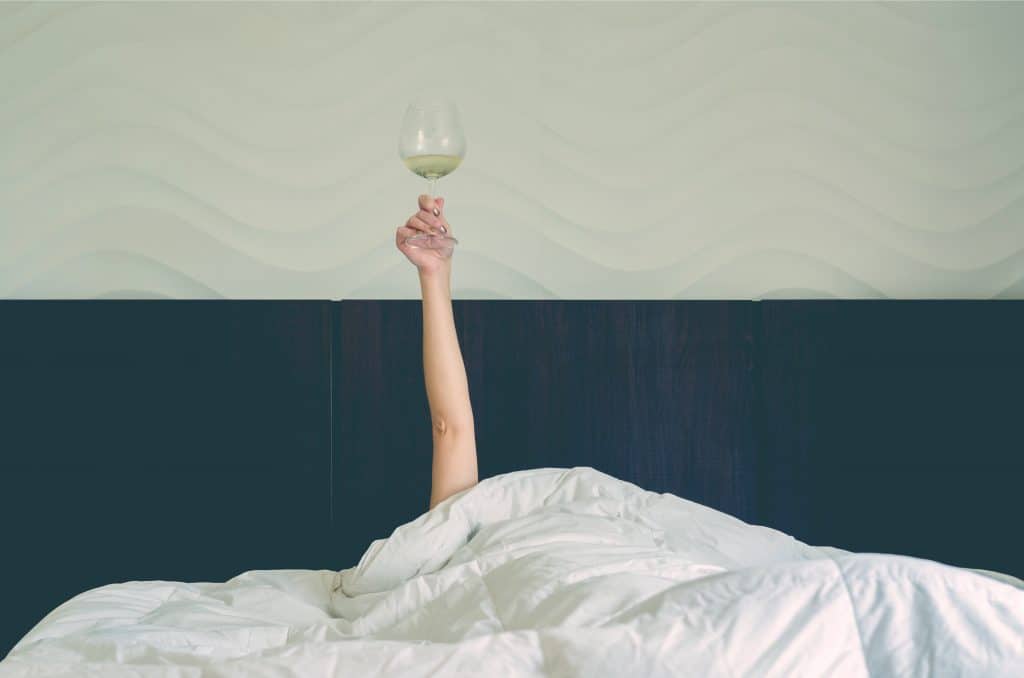 woman in bed with wine