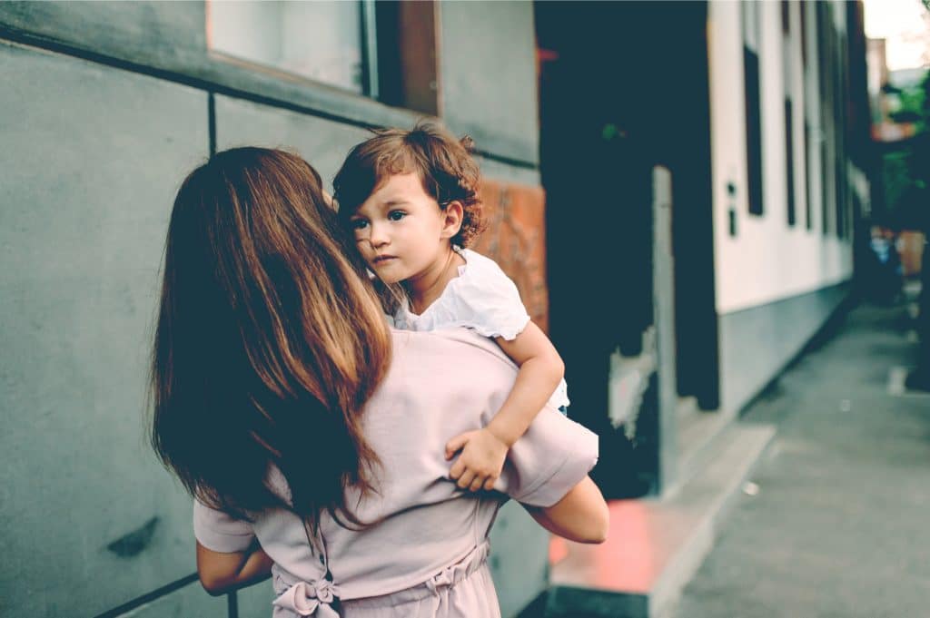 woman hold kid on street