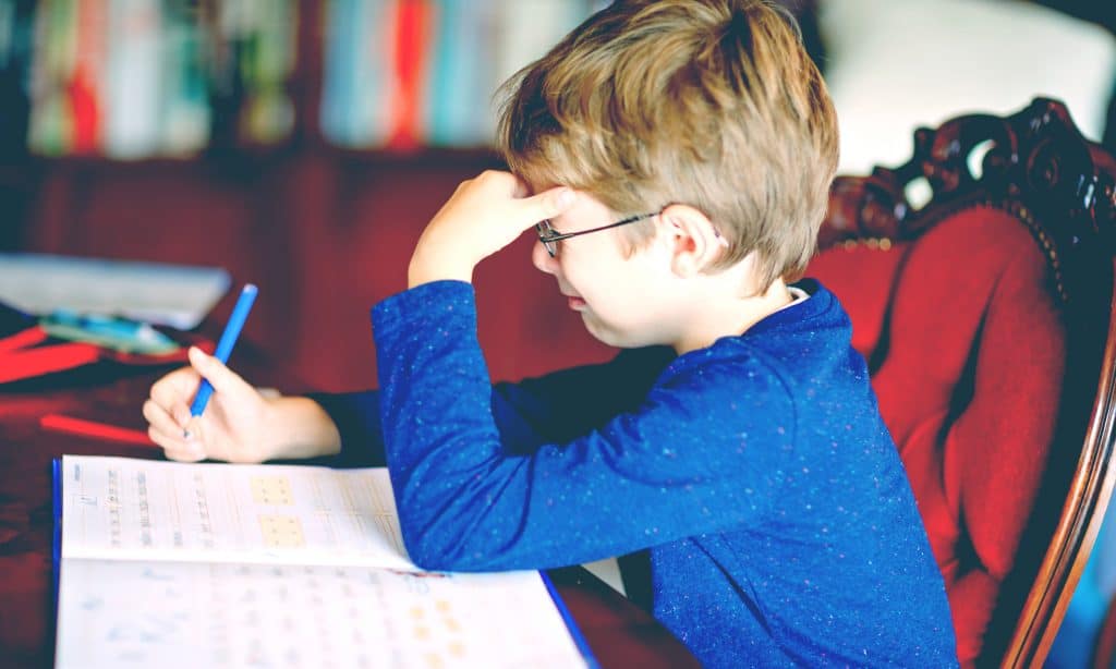 sad kid doing homeworks