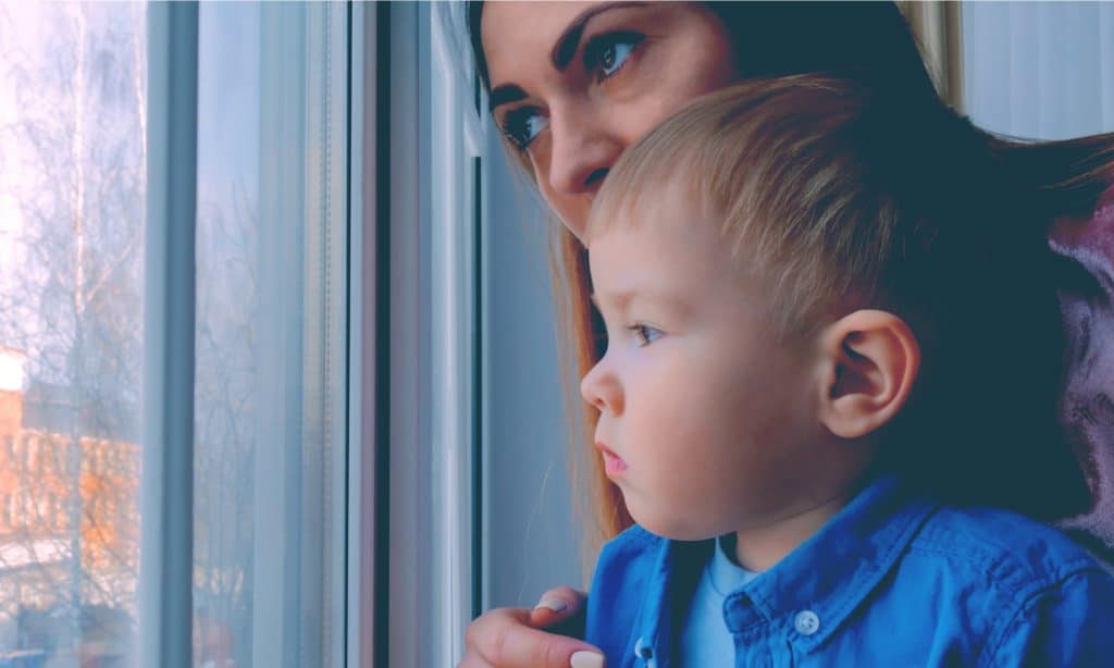 sad mother and son look at window