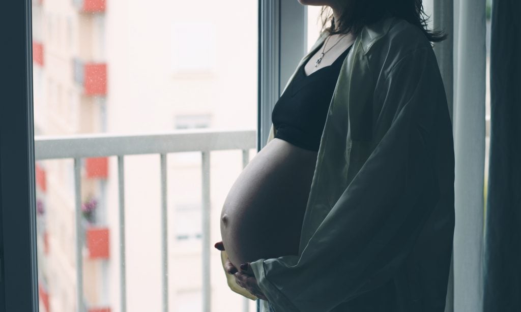 pregnant woman in front of window